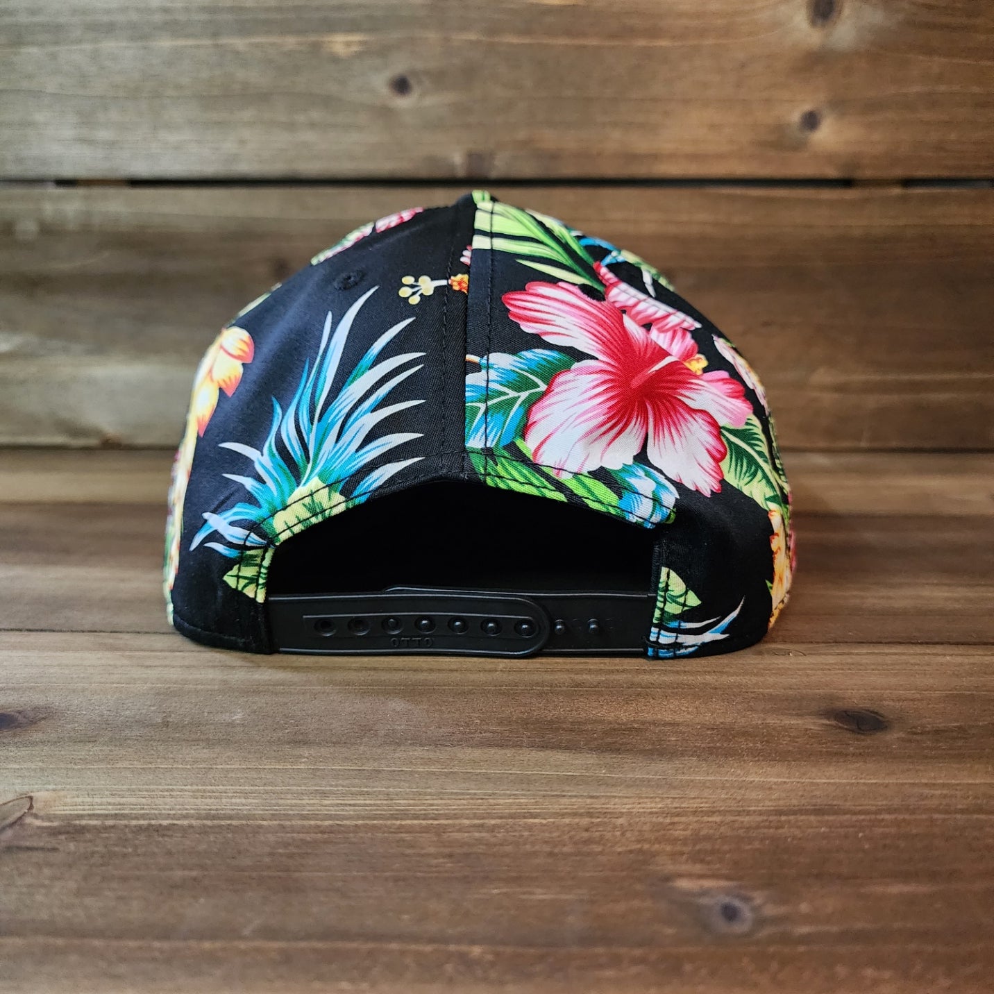 Back of snapback floral hat with adjustable strap and bold tropical design